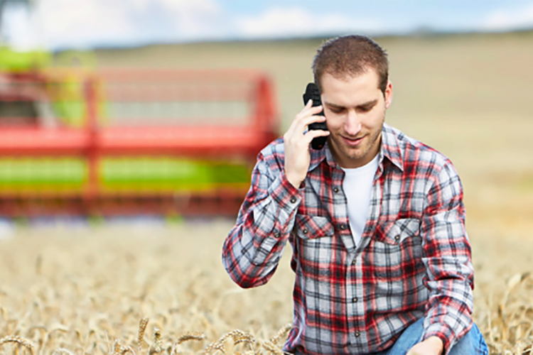 Long range DECT Phone shown being used outdoors on farmland.